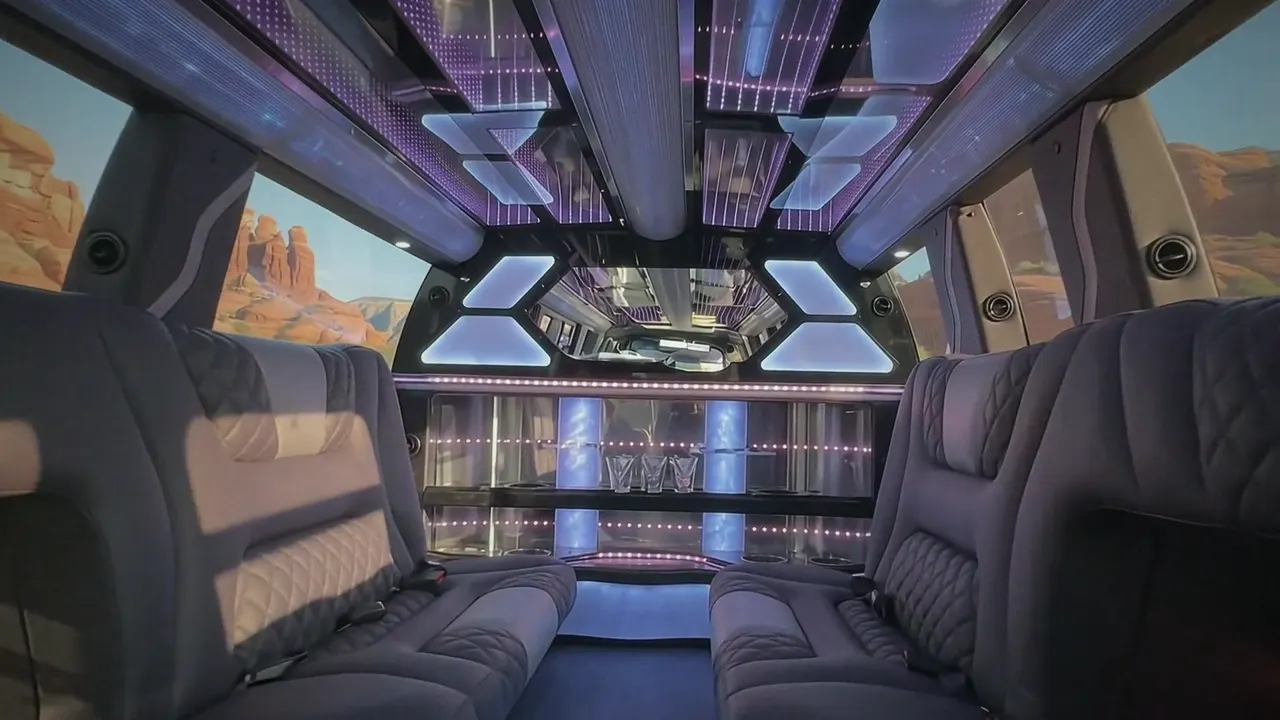 Inside the Cadillac Escalade limo in Glenwood Colorado Springs: LED light-show ceiling, leather lounge seating and lit bar